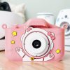 Детски фотоапарат STELS KittyCam X300 в розов цвят, поставен върху маса в уютна обстановка.